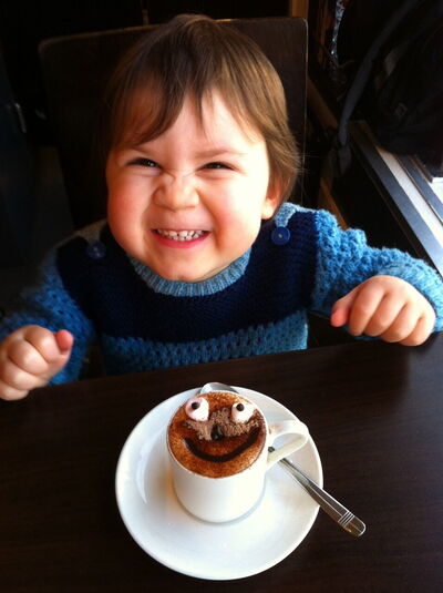 A toddler enjoying hot chocolate