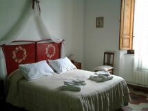 Camera doppia con grande armadio, una credenza con specchio, un tavolo con sedia.
A corredo antico lavabo in ferro e ceramica