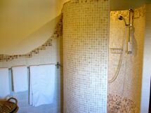 Bathroom with round shower made from travertine mosaic